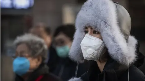 Getty Images A woman wears a protective mask after getting off a train on January 31, 2020 in Beijing, China