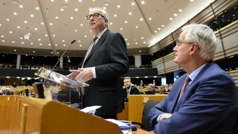 AFP President of the European Union Commission Jean-Claude Juncker (L), flanked by European Chief Brexit negotiator, Michel Barnier (R), speaks during a session of the parliament at the EU headquarters, in Brussels, on January 30, 2019