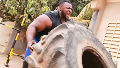 Cheick Sanou Iron Biby doing tyre flips at his back garden