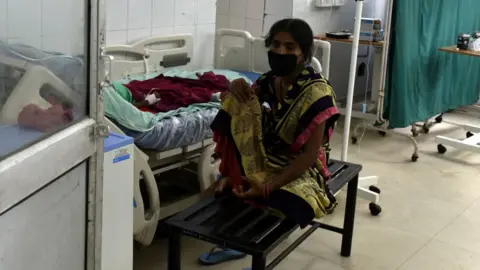 Getty Images A woman attends to her relative inside the Covid-19 ward, at Ram Manohar Lohia Hospital, in Gomti Nagar, on September, 2020 in Lucknow, India