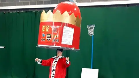 BBC John balancing a huge crown on his head for 100th world record attempt
