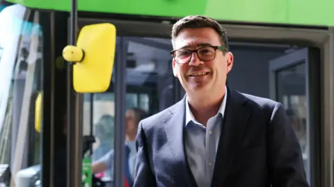 Reuters Britain's Prime Minister Andy Burnham disembarks a bus after a ride in central Bath.