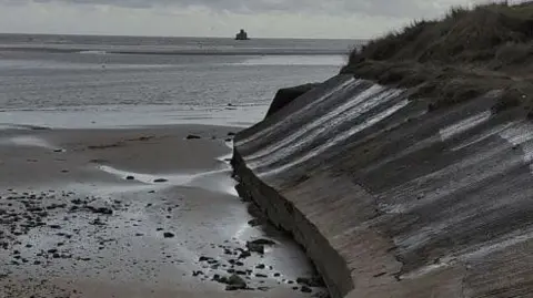 North East Lincolnshire Council The Humberston Fitties coastal embankment with a beach area in the foreground and the sea in the background.