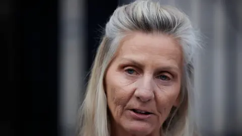 Liam McBurney Shows a woman with grey hair looking at the camera