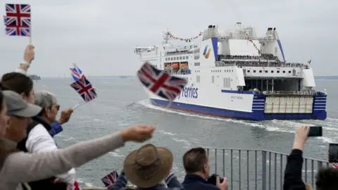 PA Media Crowds in Portsmouth waved Union and D-Day flags as the ferry passed