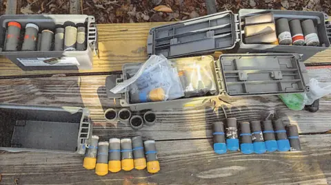 Several multi-coloured pipe bombs laid out on a table