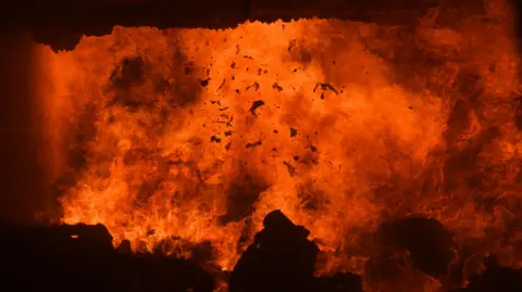 Getty Images Rubbish being burnt in an incinerator. Debris can be seen among the flames.