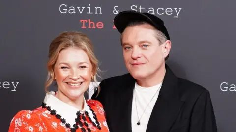 Joanna Page and Mathew Horne looking straight at the camera and smiling