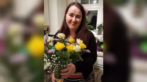 David Walker Laura Walker holding flowers and smiling