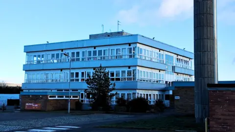 A three-storey white and grey primary school building