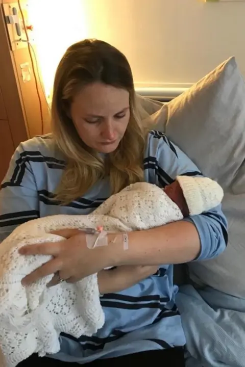 Eilidh Jamieson A woman in a hospital bed holds her baby daughter