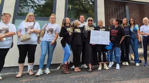 Stuart Woodward/BBC A group of 13 people standing outside Southend Crown Court. They say they are campaigning for justice for the dogs. One is holding a white placard.