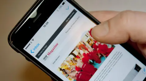 BBC A thumb scrolling on an iPhone