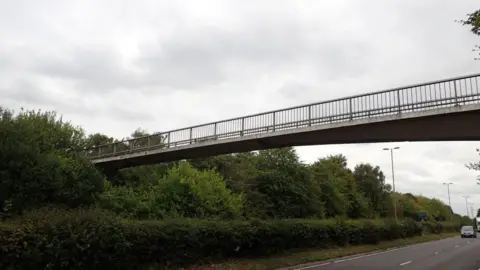 Oxfordshire County Council The Cottesmore footbridge is a narrow bridge over a busy dual carriageway.