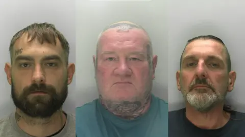 Three mugshots side by side, showing a man with a brown beard and short brown hair and a tattoo above his eyebrow, another who is bald with tattoos on his head, sides of face and neck, and another with slicked back dark but greying hair and a beard of the same colour.