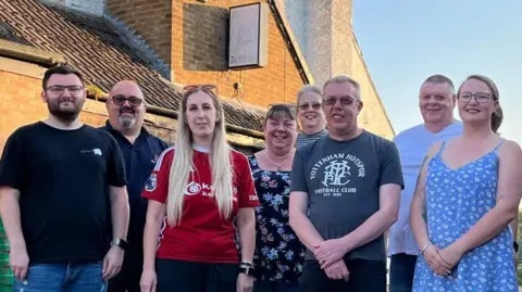 BBC Members, committee members, and trustees of the Old Mill Club standing in front of the building.