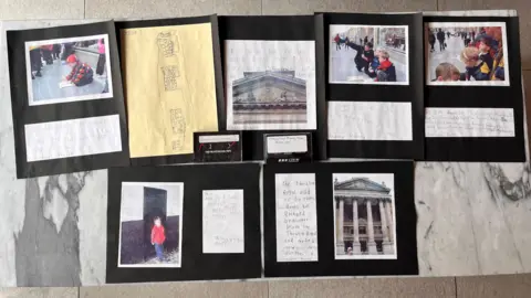 Newcastle City Council Photographs of children writing on paper on a concrete floor appear above written notes. There are also photographs of a grand building with stone columns in a display on a table.