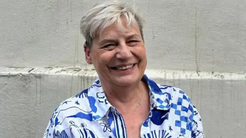 Leigh Day Helen Scarsbrook, smiling, in blue and white patterned shirt