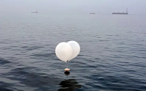 A balloon carrying various objects including what appeared to be trash, believed to have been sent by North Korea, is pictured at the sea off Incheon, South Korea