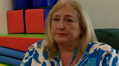 Woman with shoulder length brown hair looks at camera