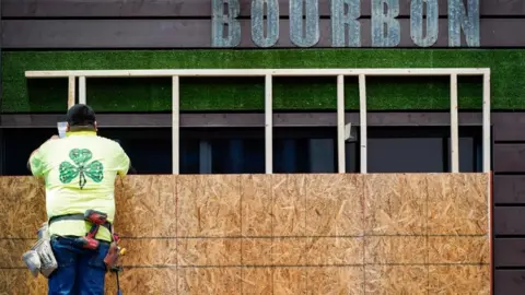 Reuters A worker boards the windows of a restaurant