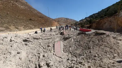 Reuters The massive crater in the middle of the road near the Masnaa crossing on 4 October 2024