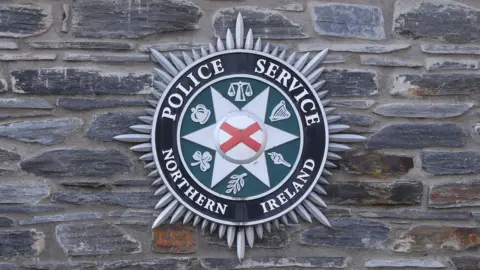 PSNI logo on a brick wall