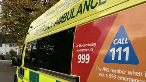 West Midlands Ambulance Service A close up image of a yellow ambulance with West Midlands Ambulance Service logos across it. The vehicle is parked on a residential street. 