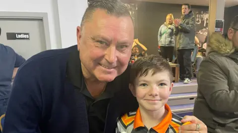 Contributed Kevin Painter is wearing a navy polo top and has his arm around George. Both are smiling inside a social club.