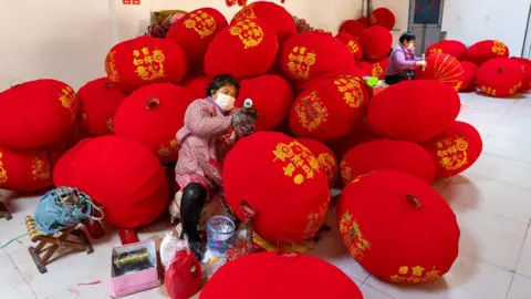 BBC/Benjamin Begley Artisans on the floor surrounded by big red lanterns