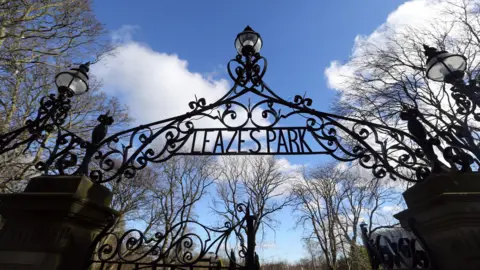 The gates to Leazes Park. A metal archway which states the park's name stands across the entrance to the park. Trees can be seen inside.