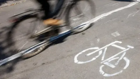 EPA A cyclist is riding along the road in a cycle lane which is clearly marked by the picture of a bike. 