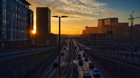 Getty Images Cars with headlights on at sunset entering and leaving underpass on dual carriageway in Leeds city centre