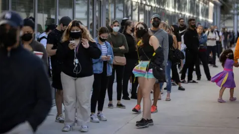 Getty Images People queue in line to get a test in Miami