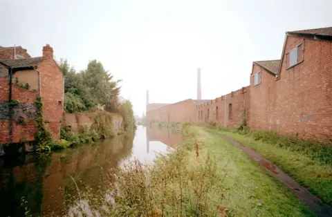 Viewed from the Staffordshire & Worcestershire Canal. The tall chimney is evidence of the steam engine which powered the mill, and the canal provided cheap transport.