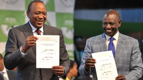 Getty Images President Kenyatta holds up certificate of election