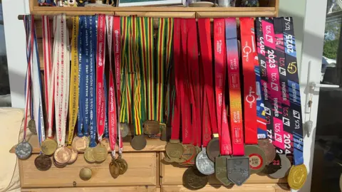 John Fairhall/BBC Mac's 45 medals from the London Marathon, dated from 1981 to 2025.