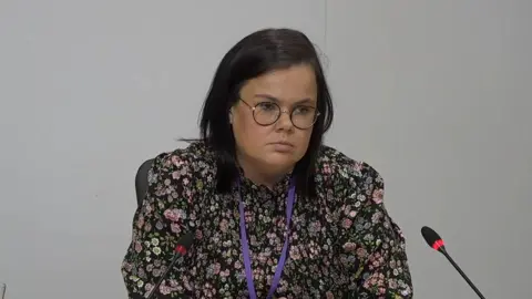 PA Media A woman with dark hair and glasses wearing a flowery top giving evidence at the Scottish Covid-19 Inquiry