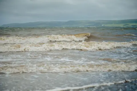 Kirstin McEwan/CT Productions A choppy sea with big, rolling waves with the green coast of south west Scotland in the distance