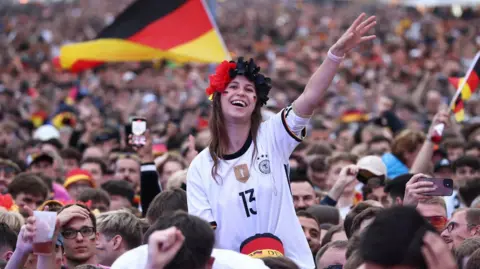 Reuters A huge crowd of Germany fans dressed in football kit celebrate as the team play in Euro 2024