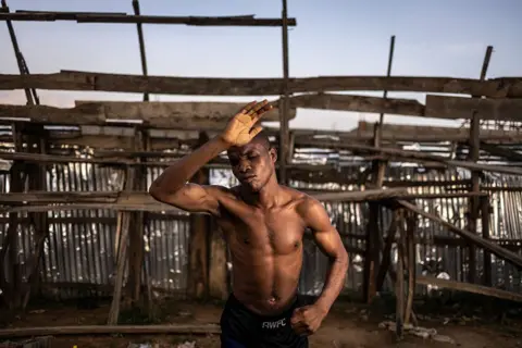 OLYMPIA DE MAISMONT / AFP / GETTY IMAGES A man poses elegantly with one closed fist and one expressive, open hand.