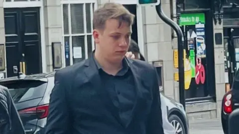 Arran Paterson arriving at court in a dark suit