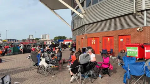Fans in camp chairs outside the stadium.