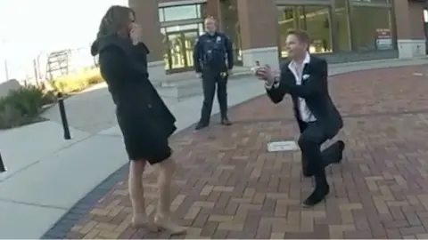 Man on one knee and lady standing