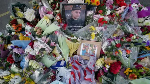 PA Media Flowers and football tops left in tribute to Harvey Willgoose