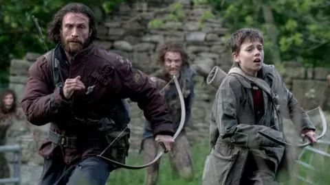 Jamie (Aaron Taylor-Johnson) and his son Spike (Alfie Williams), running from a horde of infected zombies 