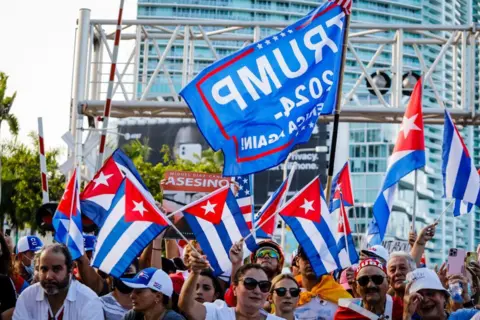 Getty Images Wamarekani wa Cuba wanampigia debe Trump wakiwa na bendera na ishara