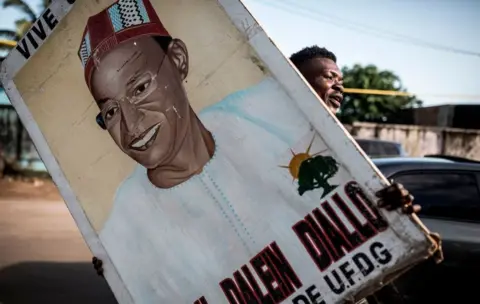 Getty Images A supporter holds up a painting of main opposition candidate, Cellou Dalein Diallo in Conakry on October 14, 2020.