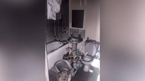Tiffany Burnt-out bathroom with smoke covered walls. 