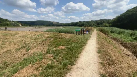 A field in front of the river and area of wetland